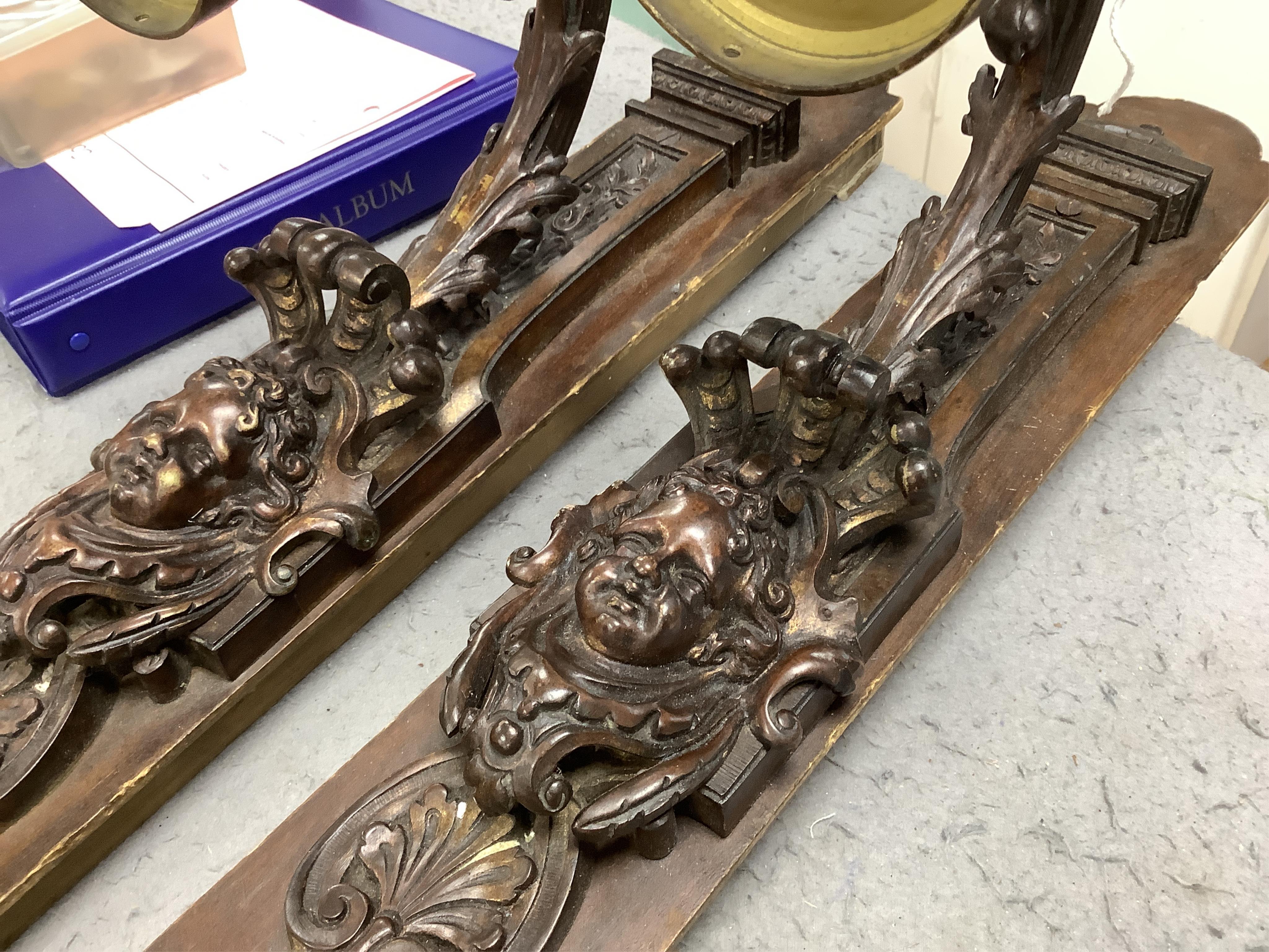 A pair of French bronze wall lights, c.1900 decorated with masks, mounted on wooden plinths, 54cm high. Condition - poor to fair